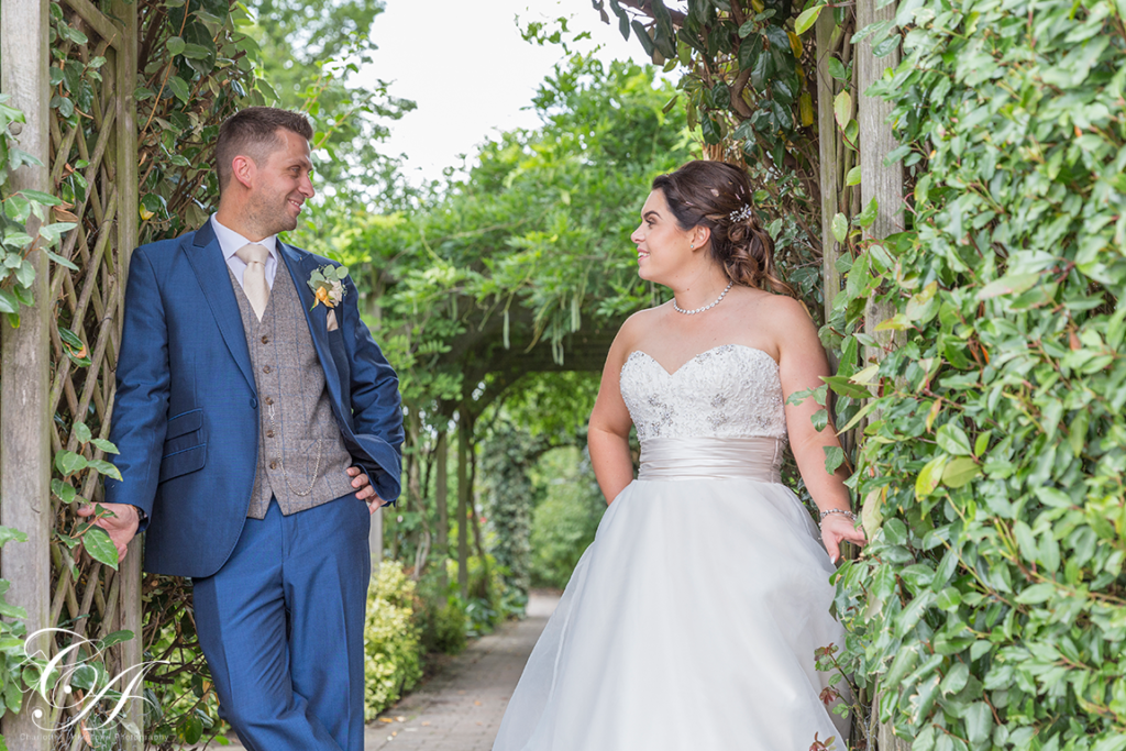 Wedding Photography from Sandburn Hall, Bride and Groom stood in the entrace to the secret garden looking at each other.