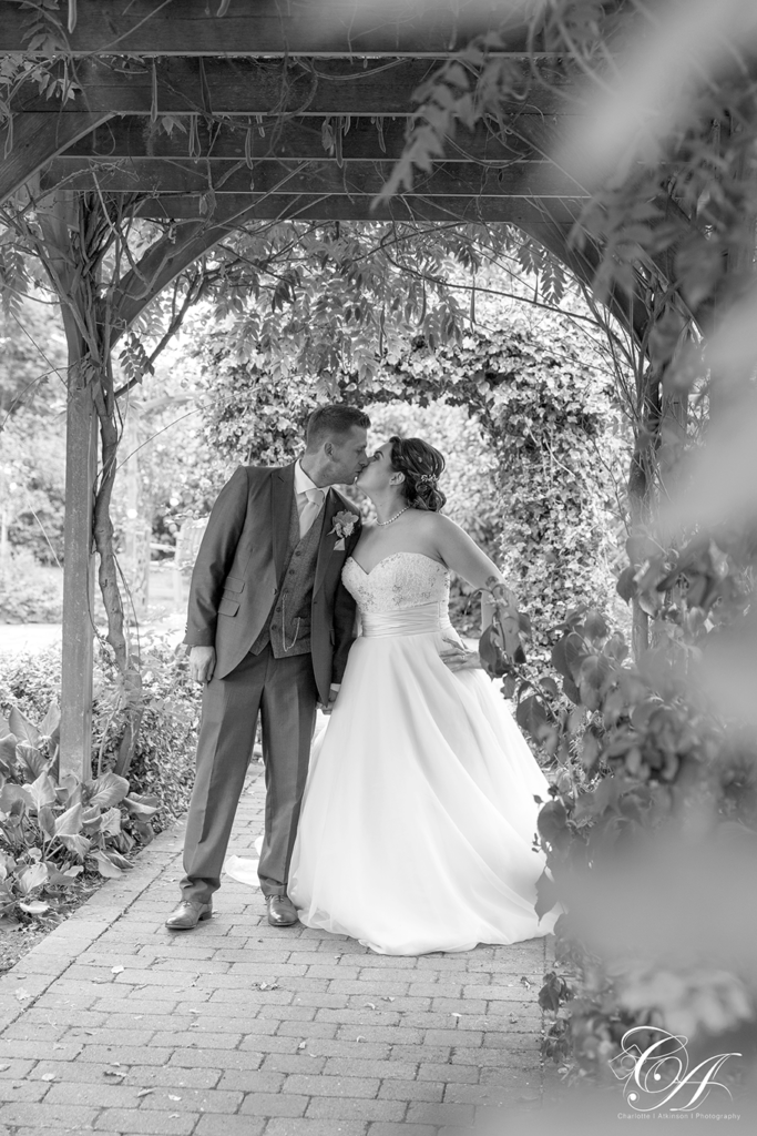 Wedding Photography from Sandburn Hall, Bride and groom kissing in the archway.